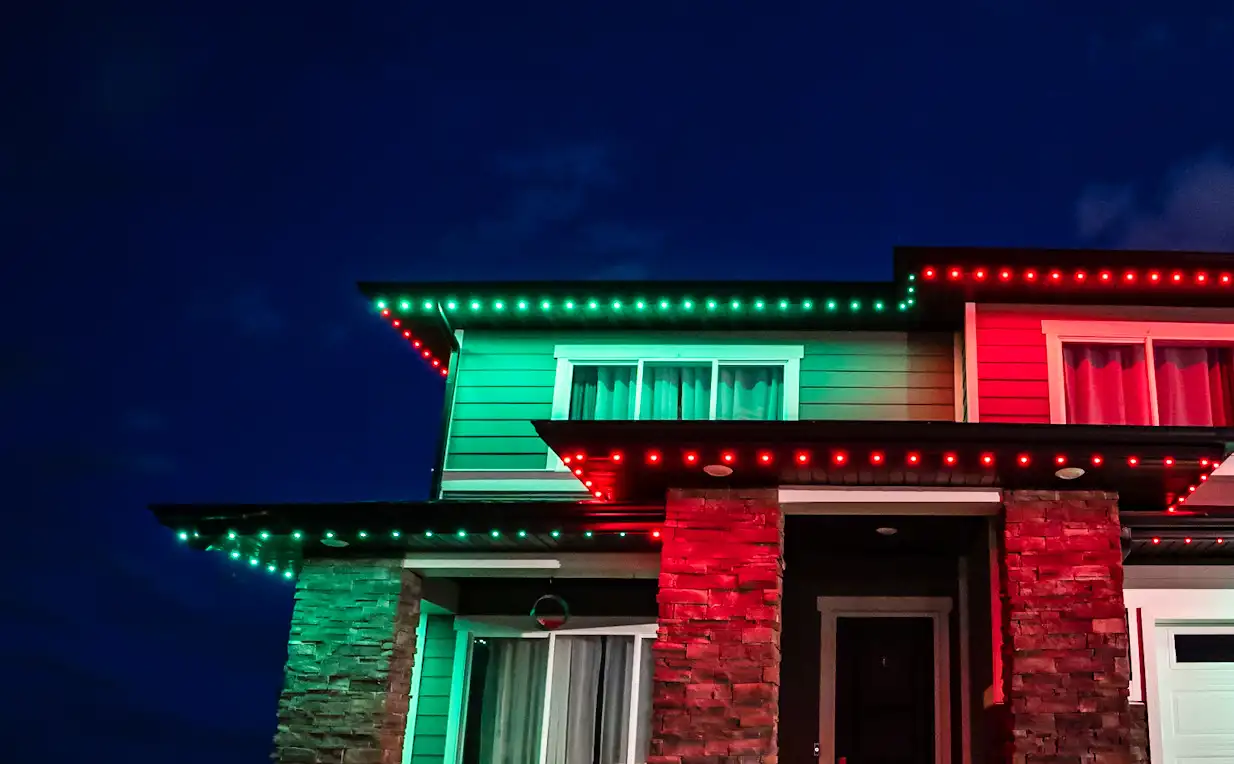 Home with red and green two-tone permanent roofline lighting
