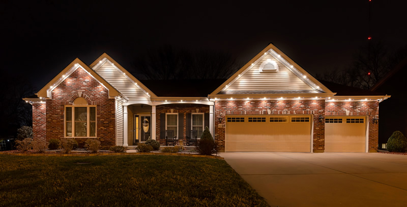 Brick ranch home with warm white permanent lighting