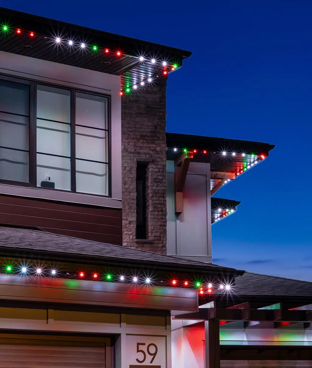 Modern home with red, green and white permanent roofline lighting, close-up detail