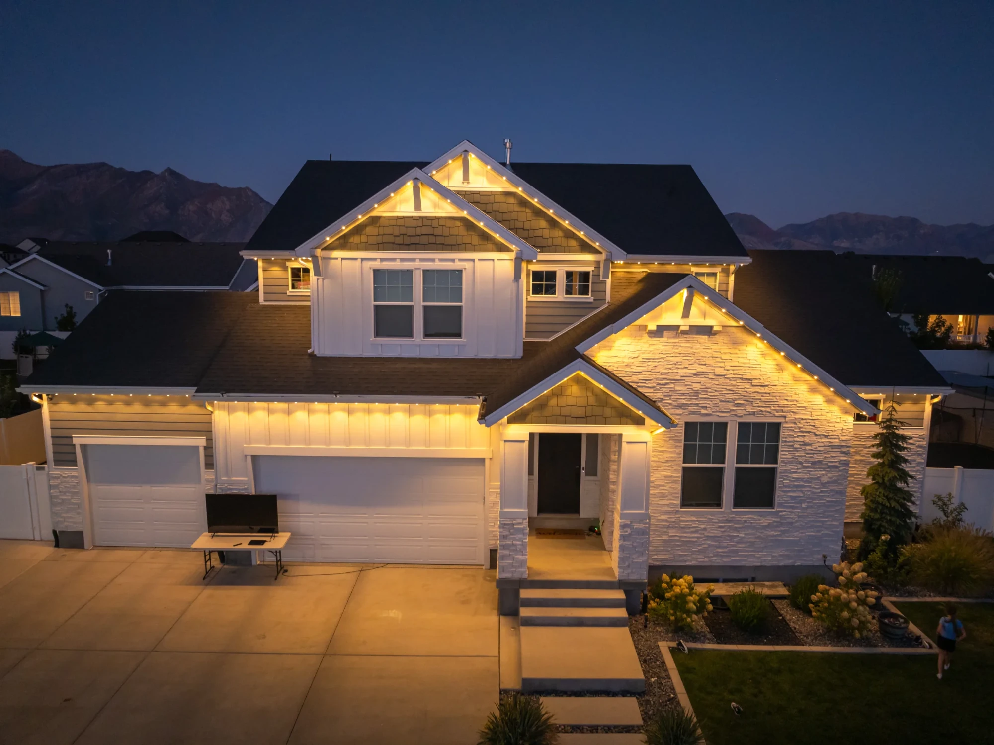 Craftsman home with warm white permanent roofline lighting, mountain view