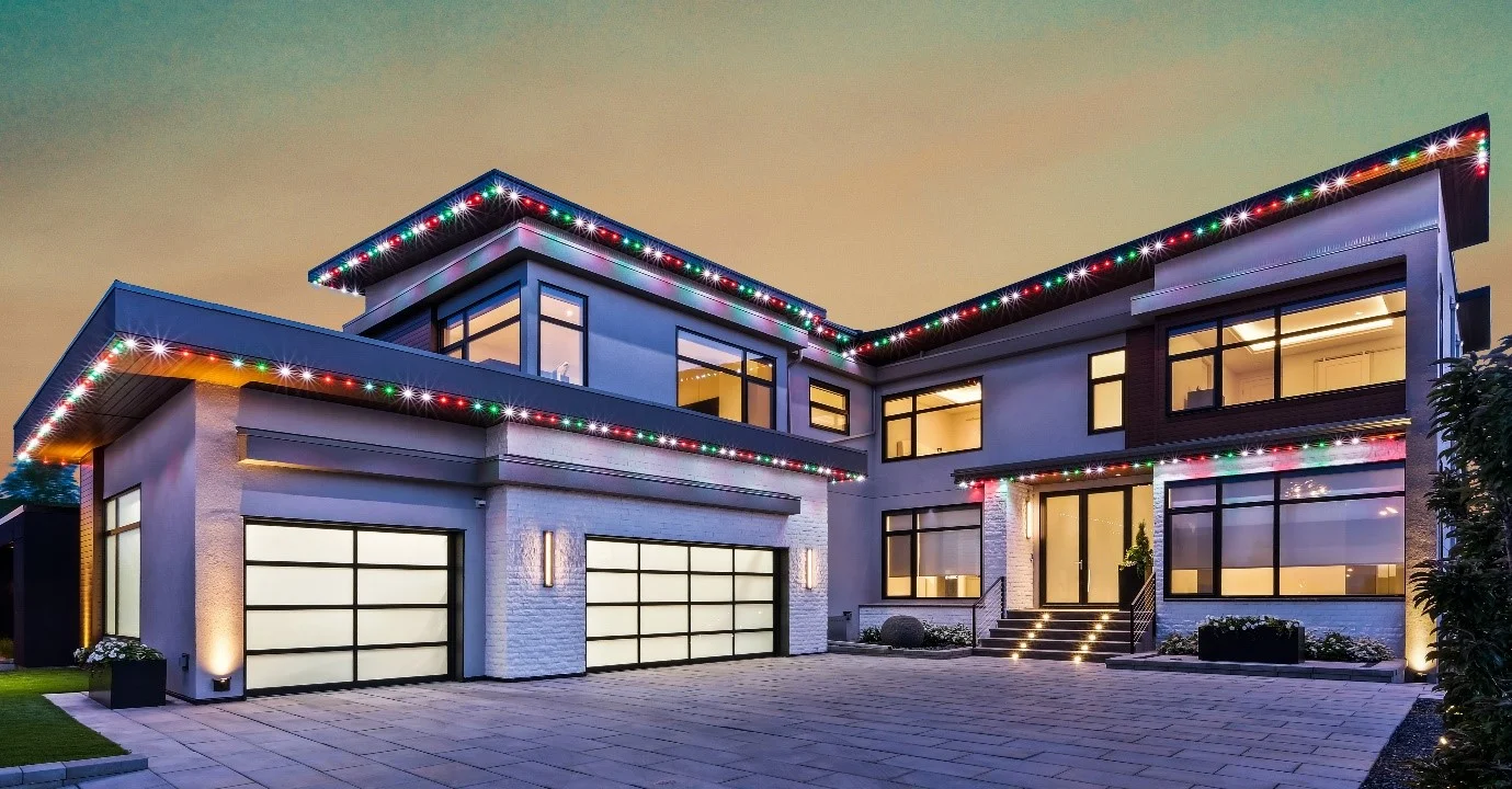 Modern home with multicolor permanent roofline lighting at dusk