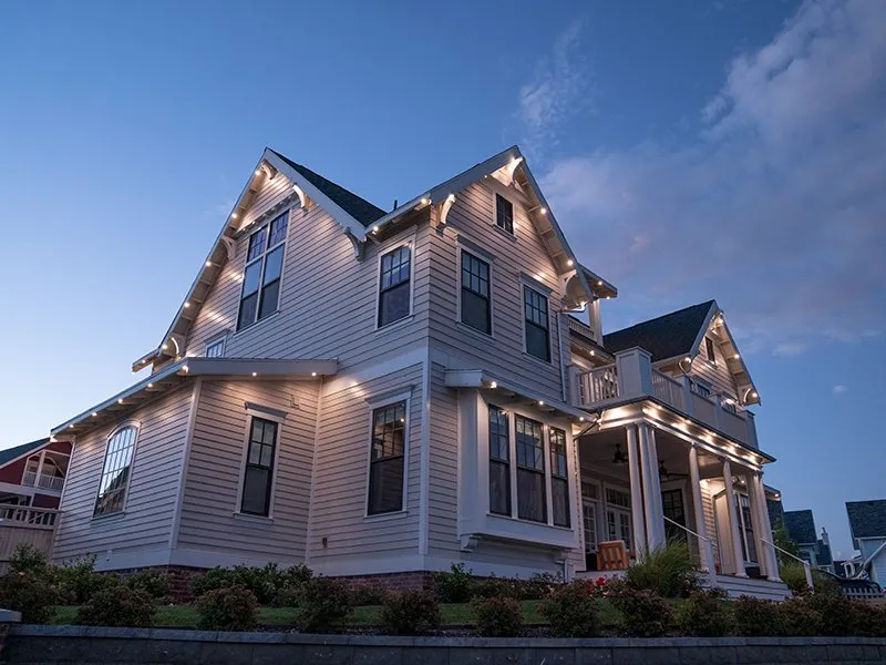 Home with warm white permanent lighting on gables and porch