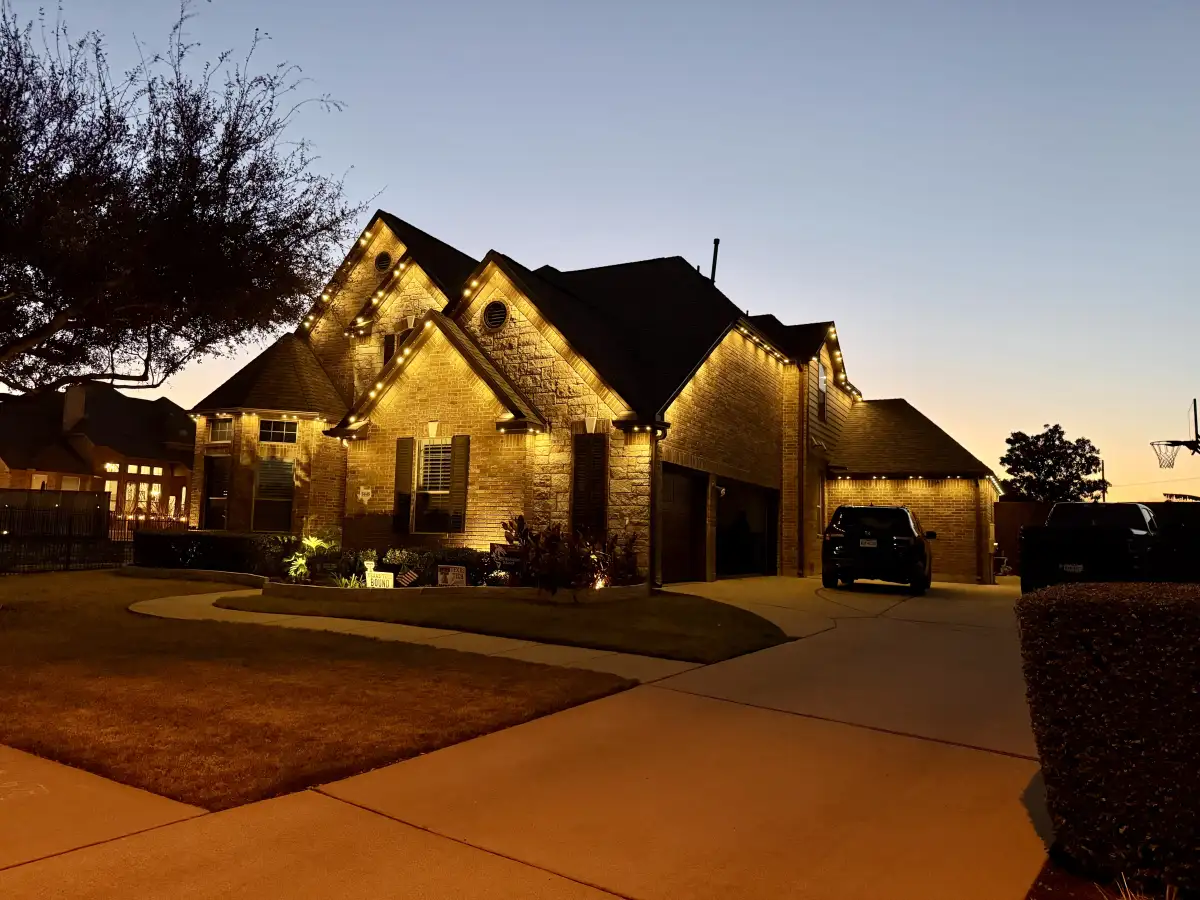 Brick home with warm white permanent lighting at sunset