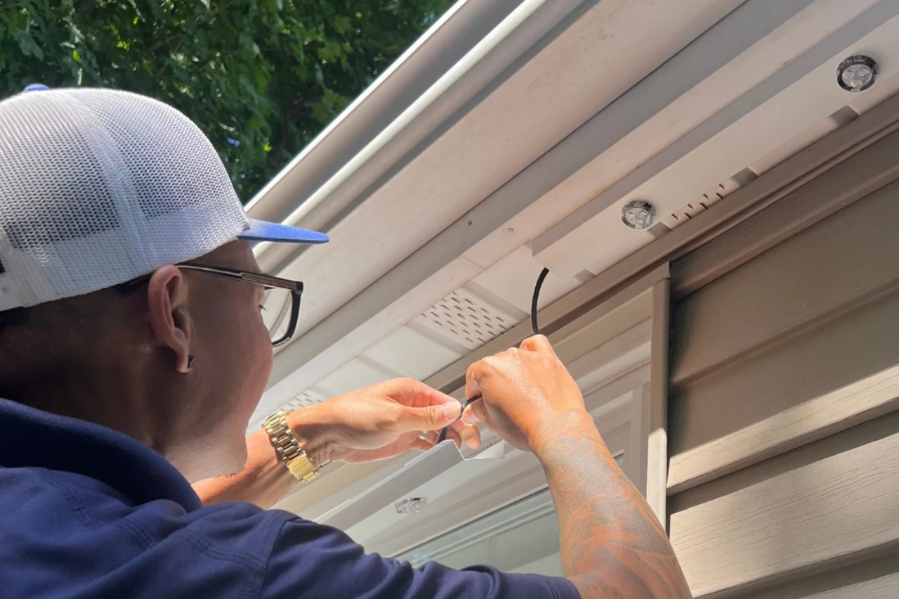 Installer clipping a light strip into a track along a soffit